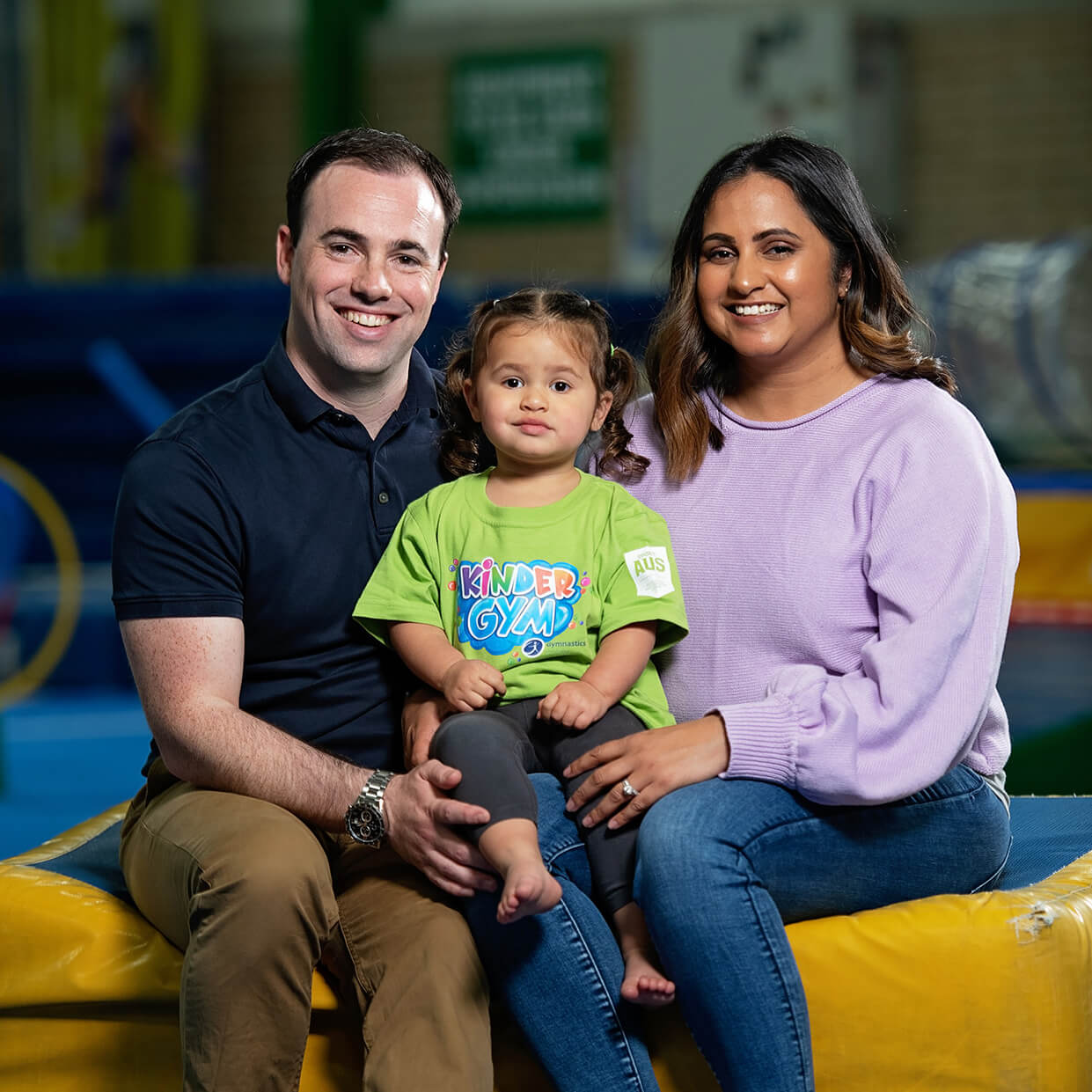 Family smiling together who attend a KinderGym